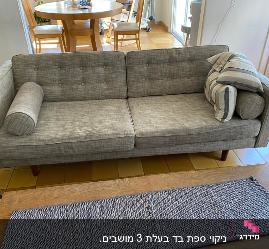 ספה אפורה עם כריות על רצפת אריחים